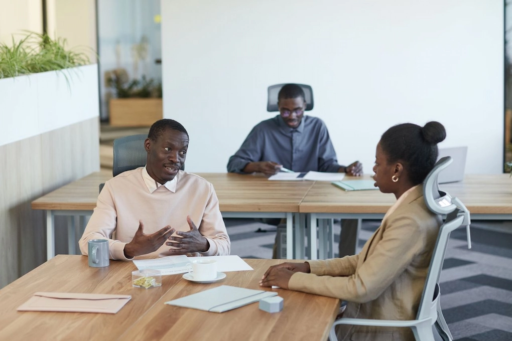 Three people working together in an office. How long the grant application process takes